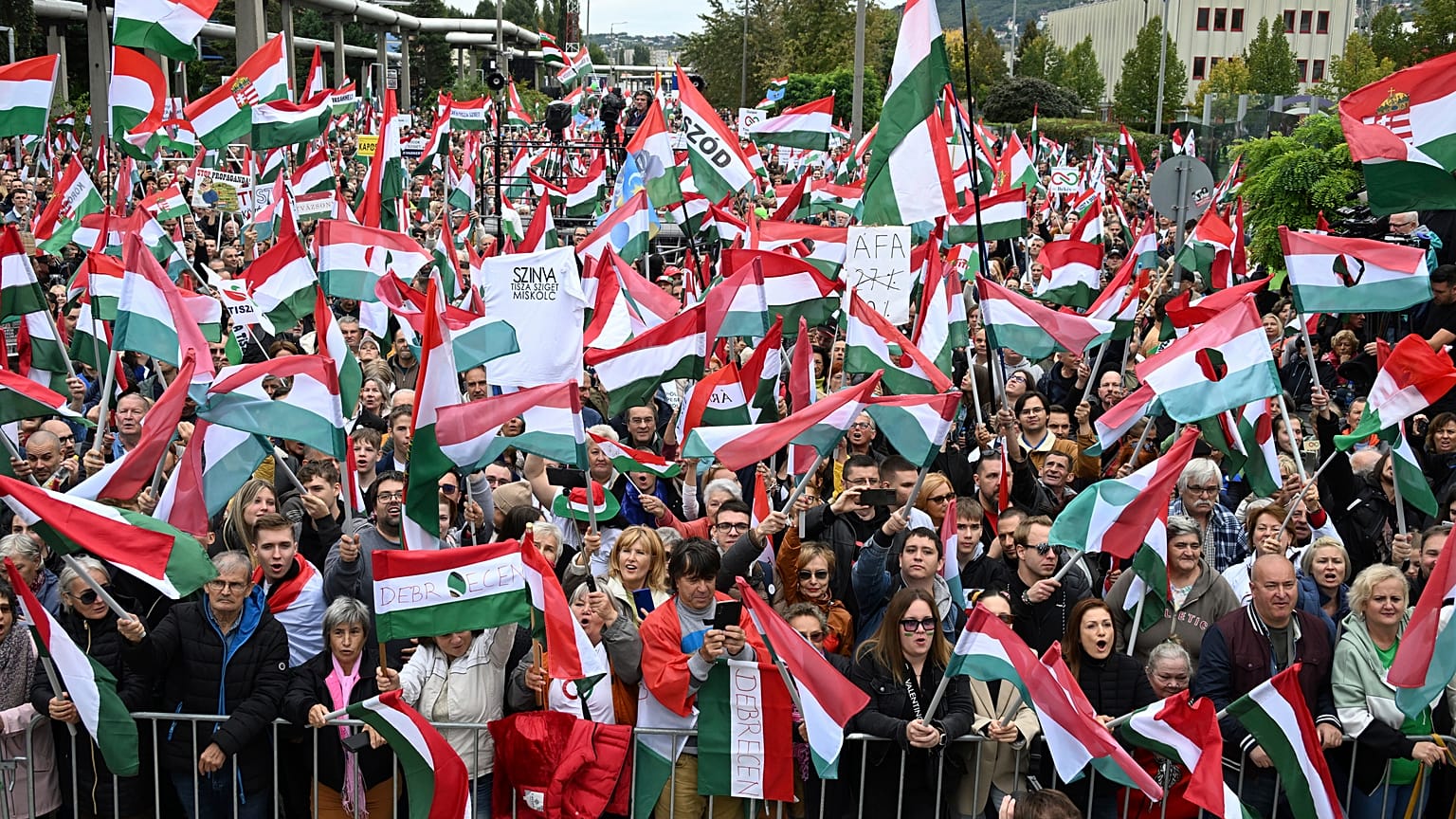 I partecipanti sventolano le bandiere nazionali durante una manifestazione contro i media pubblici presso la sede di MTVA a Budapest, il 5 ottobre 2024.