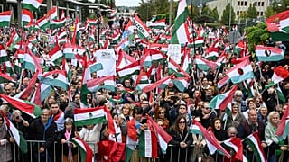 Teilnehmer schwenken Nationalflaggen während einer Demonstration gegen die öffentlich-rechtlichen Medien am Sitz der MTVA in Budapest, 5. Oktober 2024