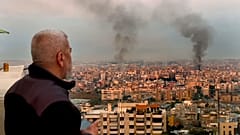 رجل ينظر بينما يتصاعد الدخان من الغارات الجوية الإسرائيلية في الضاحية، بيروت، لبنان، في وقت مبكر من يوم الأحد، 6 أكتوبر/تشرين الأول 2024