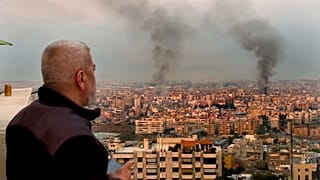 رجل ينظر بينما يتصاعد الدخان من الغارات الجوية الإسرائيلية في الضاحية، بيروت، لبنان، في وقت مبكر من يوم الأحد، 6 أكتوبر/تشرين الأول 2024