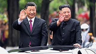 الرئيس الصيني الزائر شي جين بينغ، إلى اليسار، والزعيم الكوري الشمالي كيم جونغ أون  أثناء مرورهما في أحد شوارع بيونغ يانغ، كوريا الشمالية، في 20 يونيو 2019
