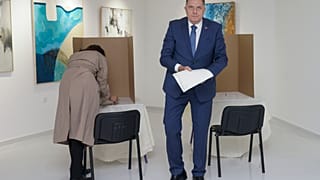 Bosnian Serb leader Milorad Dodik, right, prepares his ballot for the local elections at a polling station in Laktasi, northwest of Sarajevo, Bosnia, Sunday, Oct. 6, 2024.