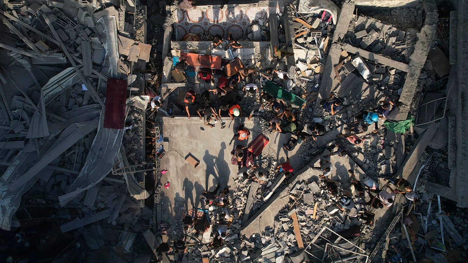  فلسطينيون يتفقدون أنقاض المباني التي استهدفتها غارة جوية إسرائيلية في مخيم الشاطئ للاجئين