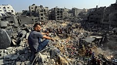 رجل يجلس على الأنقاض بينما يتجول آخرون بين حطام المباني التي استهدفتها الغارات الجوية الإسرائيلية في مخيم جباليا للاجئين، شمال قطاع غزة، الأربعاء، 1 نوفمبر، 2023.