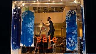 A decorator prepares a closed store's shop window for an eventual reopening in the center of Amsterdam, Thursday, Jan. 14, 2021.