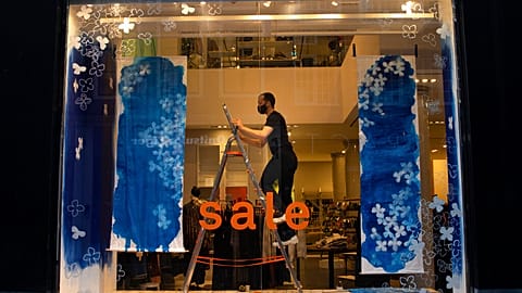 A decorator prepares a closed store's shop window for an eventual reopening in the center of Amsterdam, Thursday, Jan. 14, 2021.