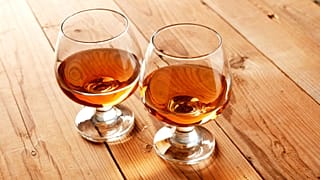 Dois copos de brandy numa mesa de madeira