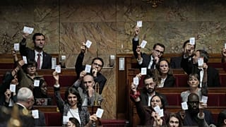 Μέλη του γαλλικού κόμματος "Ανυπότακτοι" δείχνουν τις κάρτες ψήφου τους κατά τη διάρκεια της ομιλίας του πρωθυπουργού Michel Barnier στην Εθνοσυνέλευση, στο Παρίσι, την 1η Οκτωβρίου.