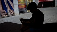 Ein 12-jähriger Junge spielt mit seinem Handy vor der Schule in Barcelona, Spanien, Montag, 17. Juni 2024