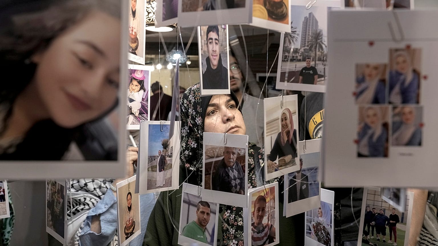 Una mujer observa fotos de víctimas palestinas de la guerra de Israel contra Hamás, en una exposición para conmemorar el primer aniversario de la guerra en la Franja de Gaza.