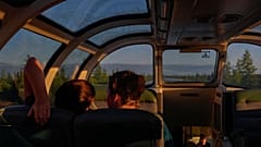 Fahrgäste im Skyline-Wagen beim Sonnenuntergang zwischen Churchill und Gilliam, Manitoba, am Donnerstag, 8. August 2024.