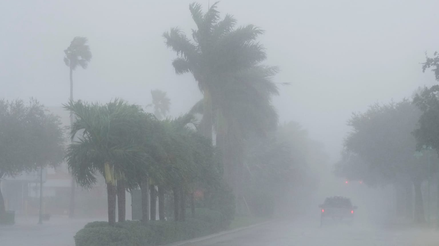 A Lee County Sheriff's officer patrols the streets of Cape Coral, Fla., as heavy rain falls ahead of Hurricane Milton
