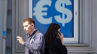 Gente pasando por delante de una oficina de cambio de divisas.