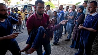 فلسطيني يحمل طفلًا مصابًا بعد غارة جوية إسرائيلية في دير البلح، قطاع غزة، الخميس، 10 أكتوبر/تشرين الأول 2024.