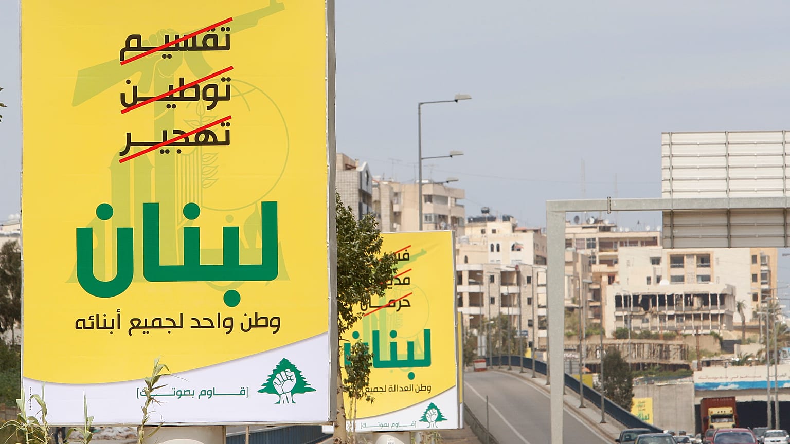 لافتات انتخابية لحزب الله مكتوب عليها باللغة العربية: ”تقسيم، توطين، تهجير (مشطوبة بالأحمر)، لبنان، 8 أبريل/نيسان 2009
