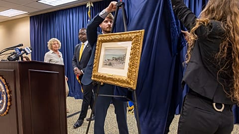 FBI agents unveil a Claude Monet painting to its original owners' descendants at the New Orleans office on Wednesday, 9 October 2024.