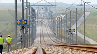 FILE: Workers walk along the high speed railway under construction between Paris and Strasbourg, 16 July 2006