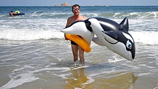 Un homme se promène avec un orque gonflable sur la plage de Sijung Ho, en Corée du Nord, avant la pandémie et la fermeture des frontières.