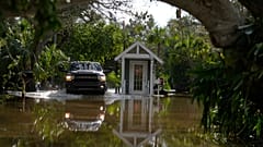Un coche avanza entre el agua en plena alerta por el huracán Milton.