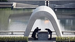 FILE - Kazumi Matsui, right, mayor of Hiroshima bows, at Hiroshima Memorial Cenotaph, at the Hiroshima Peace Memorial Park in Hiroshima, 6 August 2015