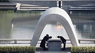 FILE - Kazumi Matsui, right, mayor of Hiroshima bows, at Hiroshima Memorial Cenotaph, at the Hiroshima Peace Memorial Park in Hiroshima, 6 August 2015