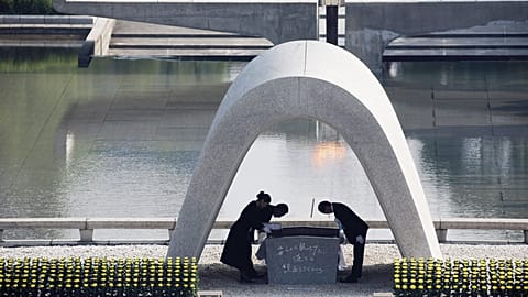 FILE - Kazumi Matsui, right, mayor of Hiroshima bows, at Hiroshima Memorial Cenotaph, at the Hiroshima Peace Memorial Park in Hiroshima, 6 August 2015