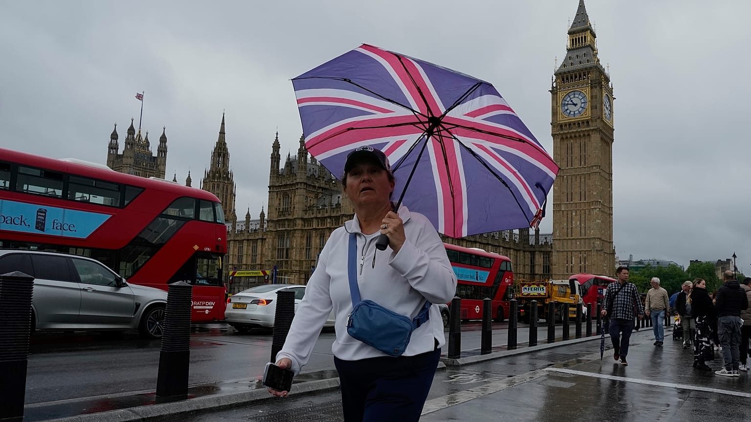 Bir kadın Londra'daki Parlamento Binası'nın önünden geçiyor