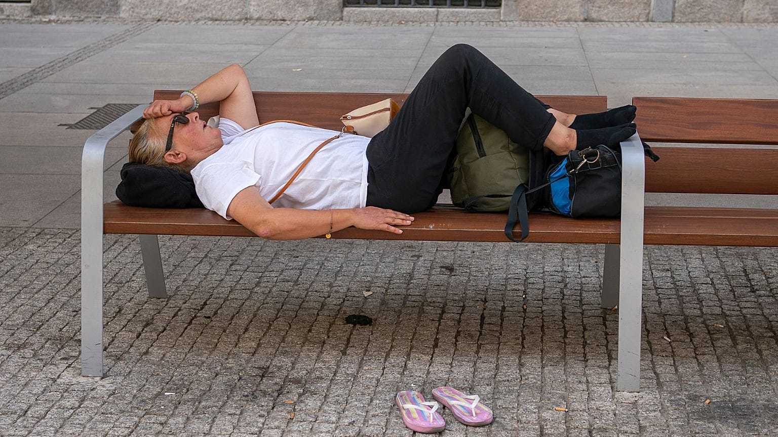 Une femme s'allonge sur un banc pendant une vague de chaleur à Madrid, Espagne, août 2021.