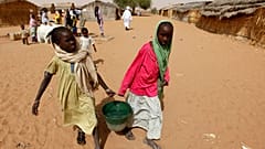 Két lány vizet cipel a Zamzam menekülttáborban 