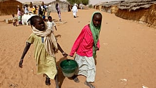 Két lány vizet cipel a Zamzam menekülttáborban 