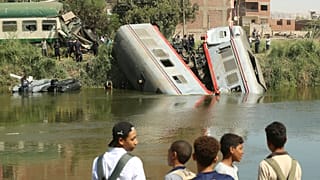 مواطنون مصريون يقفون قرب مكان حادث اصطدام قطار للمسافرين وسقوط عربتين في الماء أثناء توجه القطار إلى القاهرة. تاريخ: 13.10.2024