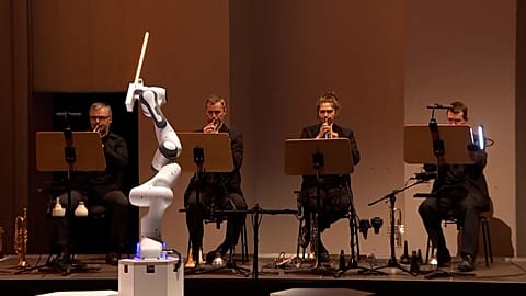 A robot conducts performers of the Dresden Symphony Orchestra as they perform 'Robot Symphony' to audiences in the German city on Saturday, 12 October, 2024.