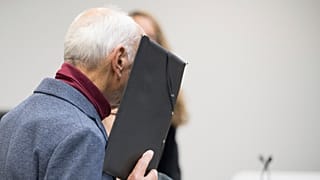 Sanık, 14 Ekim 2024 Pazartesi günü Berlin'de bölge mahkemesinin önünde duruyor ve karardan önce yüzünü kapatıyor.
