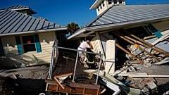 Bir mülk sahibi, Pazar günü Florida Englewood'da Manasota Key'de eşiyle birlikte yaşadığı ikinci kattaki birimin kalıntılarına baktı