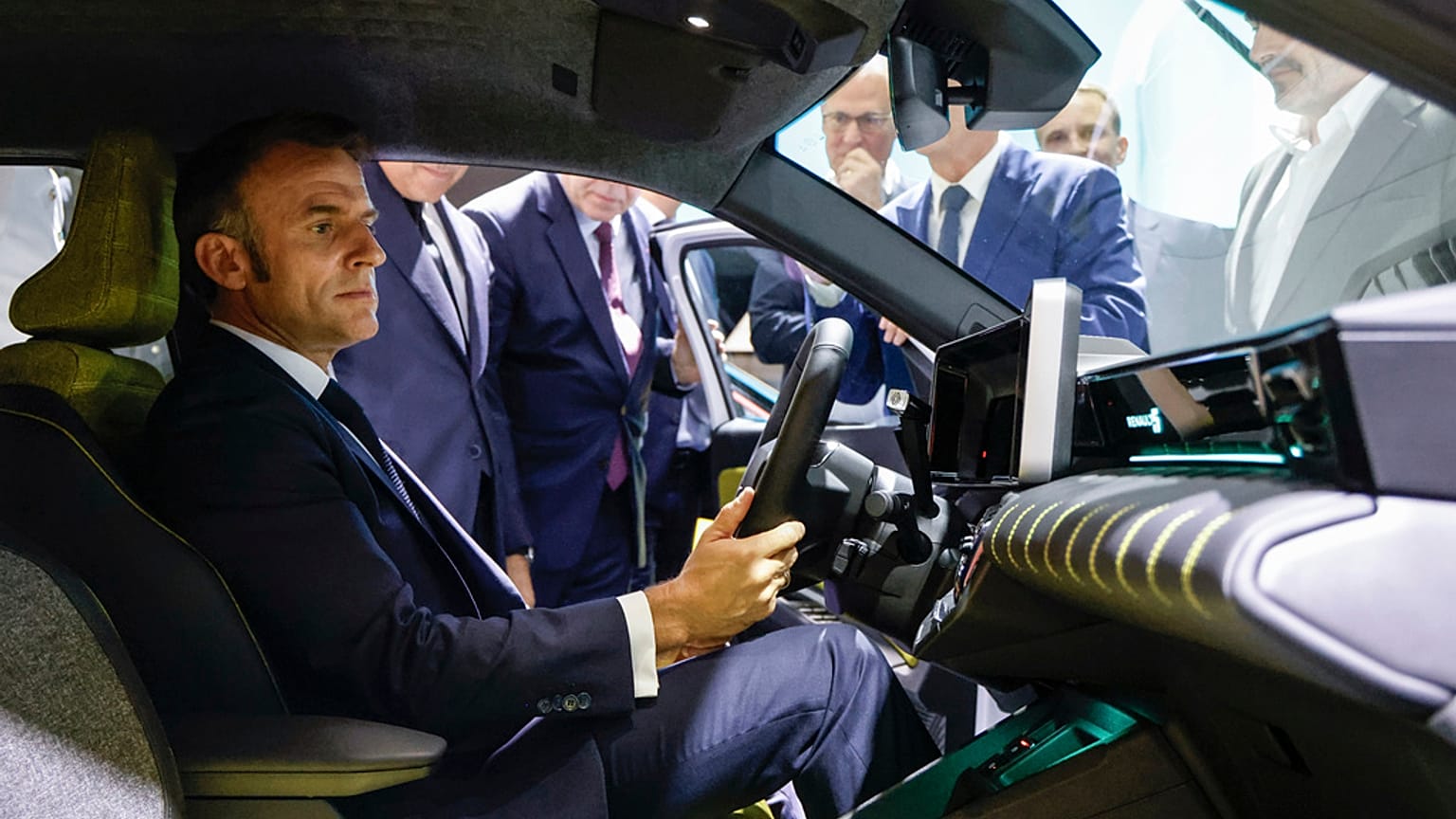 French President Emmanuel Macron sits in Renault R5 car as he visits the Renault stand at the Paris Auto Show in Paris, Monday, Oct. 14, 2024. 