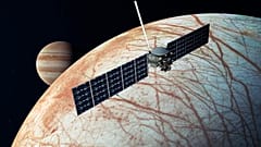 A NASA illusztrációján az Europa Clipper űrszonda látható az Europa közelében, a Jupiterrel a háttérben