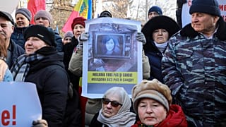 Uma mulher segura uma faixa com o presidente do país, Maia Sandu, onde se lê "Moldávia sem PAS e Sandu", durante um protesto em Chisinau, Moldávia, quinta-feira, 1 de fevereiro de 2024.
