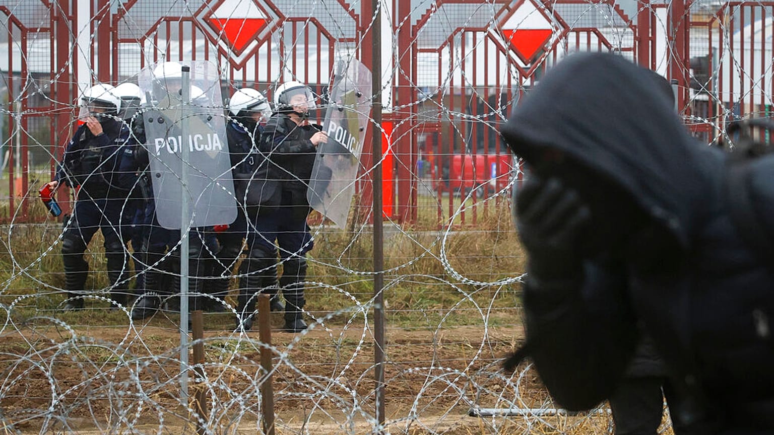 Soldati polacchi  dall'altra parte del filo spinato durante gli scontri coi migranti al confine bielorusso-polacco vicino a Grodno, 2021