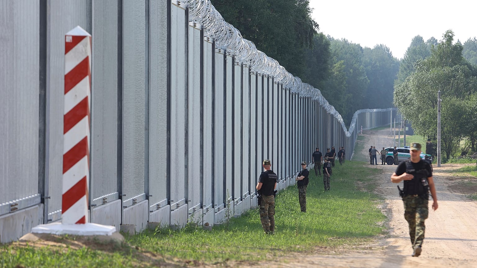 FILE - Polish border guards patrol a metal wall on the border between Poland and Belarus, near Kuznice, Poland.