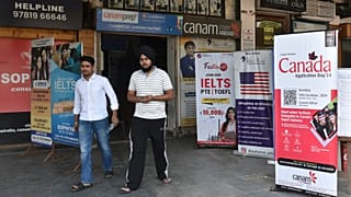 Hindistan'ın kuzeyindeki Pencap eyaletine bağlı Amritsar'daki bir pazarda, öğrencileri Kanada ve diğer ülkelerde okumaya davet eden pankartların önünden geçiyor, 15 Ekim 2024 