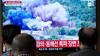 Bir TV ekranı, 15 Ekim Salı günü Seul'deki Seul Tren İstasyonu'nda bir haber programı sırasında Kuzey Kore'nin Koreler arası yolların kuzey tarafının bazı kısımlarını havaya uçurduğunu bildiriyor