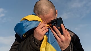 Недавно обмененный украинский военнопленный плачет, звоня своим родственникам после обмена пленными на границе Украины и России