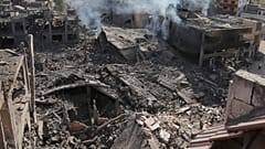 El humo se eleva desde los edificios destruidos que fueron alcanzados por los ataques aéreos israelíes en la localidad de Qana, en el sur del Líbano, este miércoles