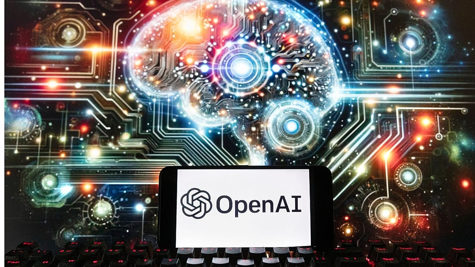 FILE - The OpenAI logo is displayed on a cell phone with an image on a computer screen generated by ChatGPT's Dall-E text-to-image model, Dec. 8, 2023, in Boston.