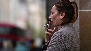 A woman smokes on a London street in April 2024.