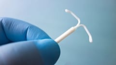 A medical worker holds an IUD.