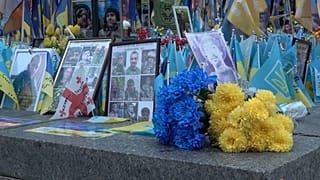 Gros plan sur des fleurs à côté de portraits de soldats morts au combat.