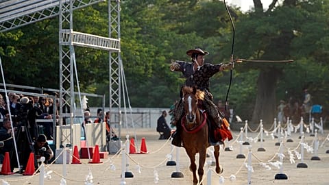Les visiteurs s'adonnent au tir à l'arc à cheval traditionnel japonais au sanctuaire Toshogu de Nikko.