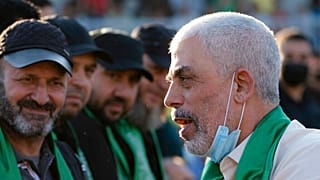 Militantes montam guarda à volta do palco enquanto Yahya Sinwar cumprimenta os apoiantes num comício, segunda-feira, 24 de maio de 2021, na cidade de Gaza.