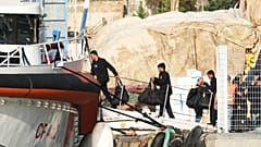 Migrantes interceptados en aguas internacionales y enviados a un centro de acogida en Albania a principios de esta semana, suben a bordo de un buque guardacostas italiano, 19 de octubre de 2024.